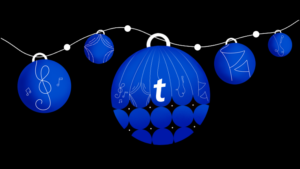 5 blåa julgranskulor med noter, flaggor, mikrofoner, stjärnor och Ticketmasters t som mönster.